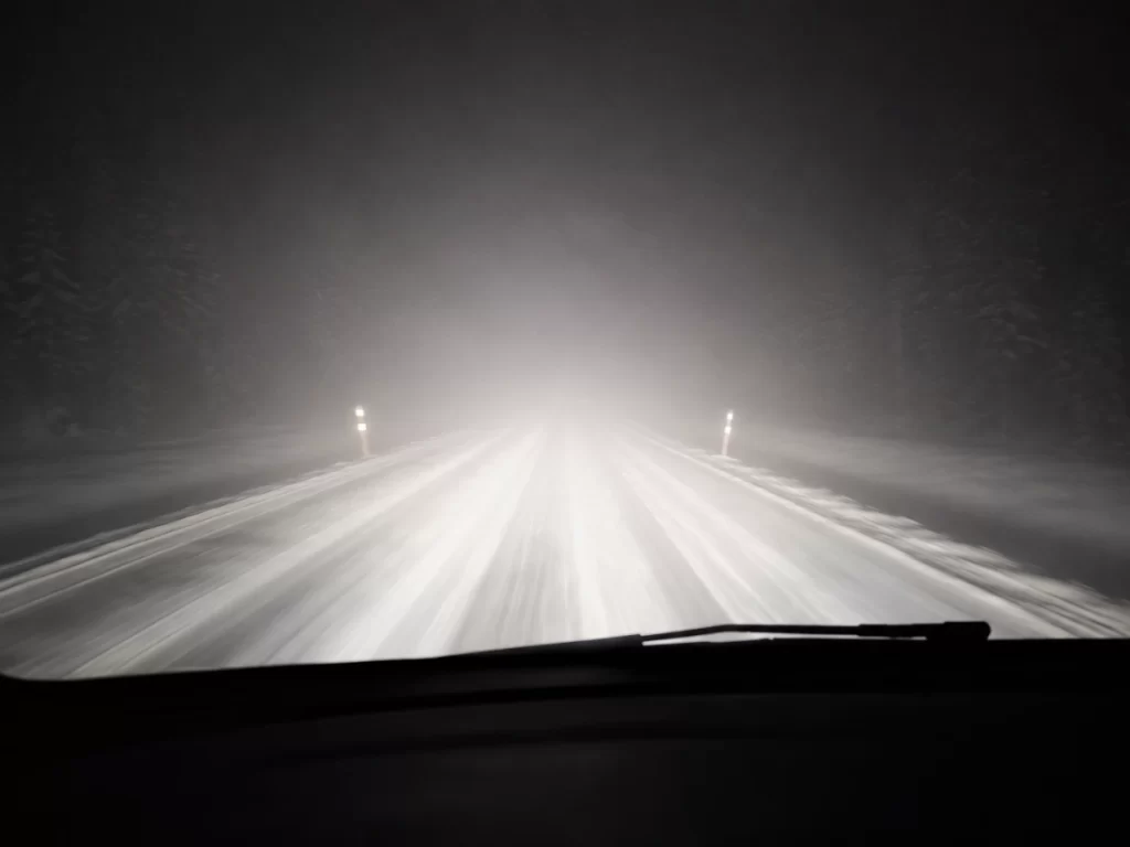 Snow-covered road in Lapland during a dark winter night
