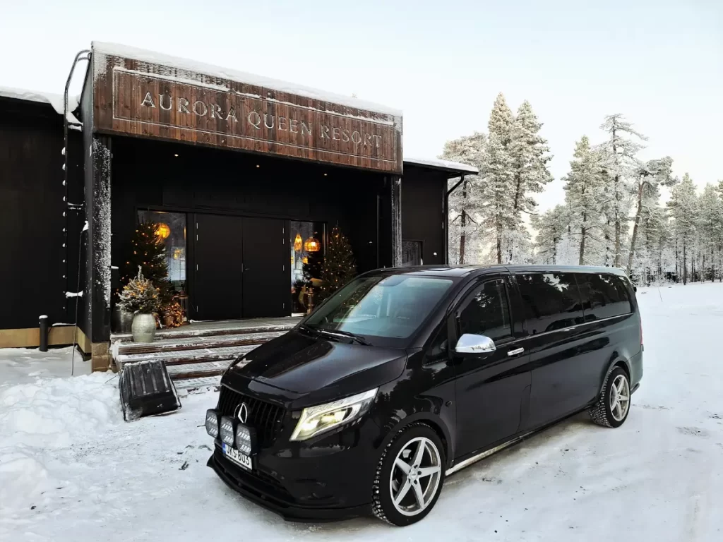 Black Mercedes-Benz private transfer vehicle in front of Aurora Queen Resort in snowy Lapland
